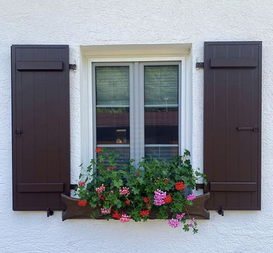 Fenster mit Blumenkasten und offenen Fensterläden