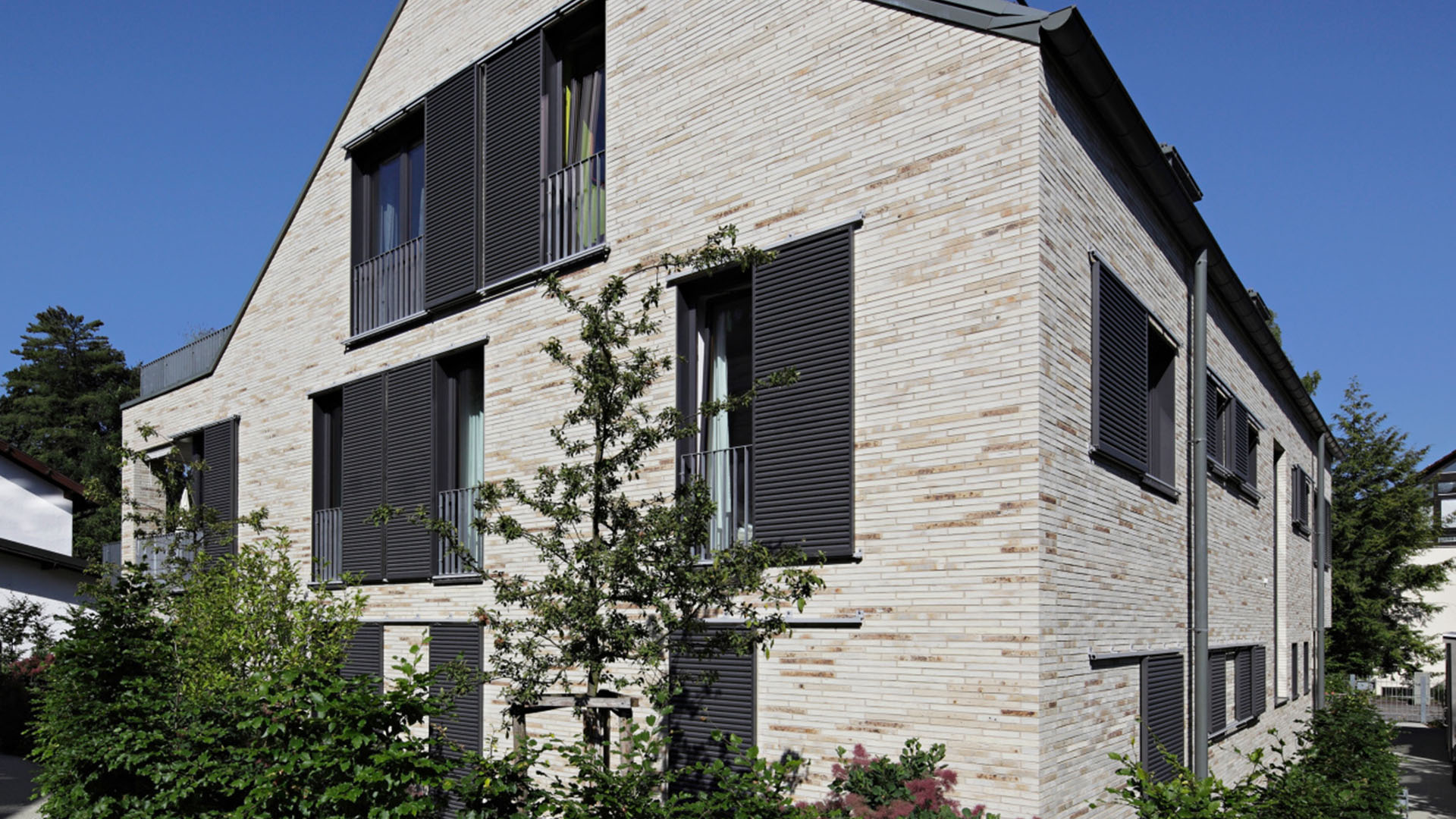 Hausfassade mit mehreren Schiebefensterläden mit Lamellen