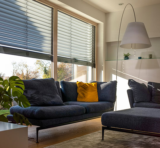Sitzgruppe vor halb geöffneten Jalousien im Wohnzimmer