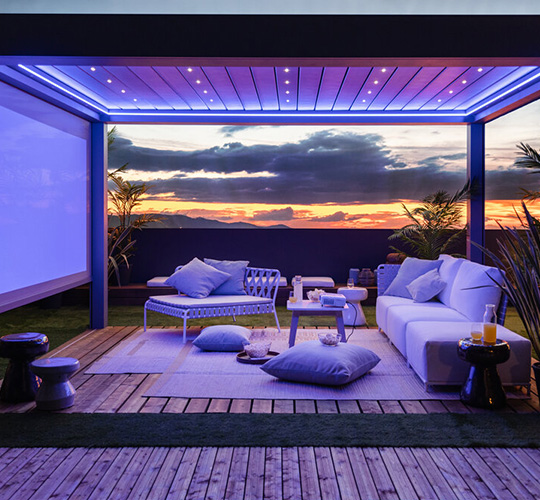 Lamellendach mit Sichtschutz und LED-Beleuchtung bei abendlicher Stimmung