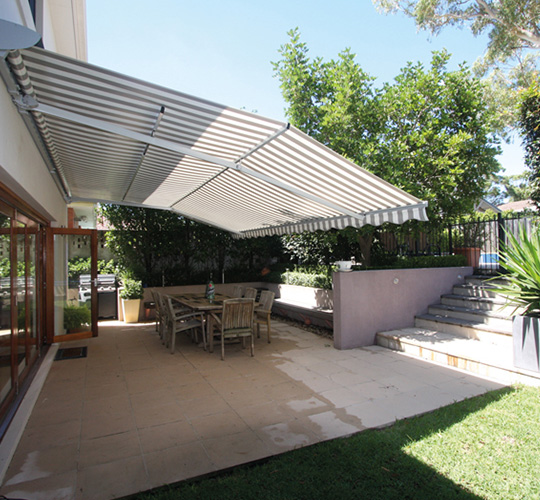 Ausgefahrene großflächige Markise über Terrasse eines Cafés