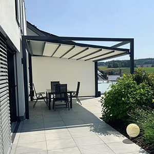 Seitenansicht einer Pergola mit Essgruppe auf einer Terrasse