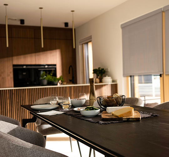 Frühstückstich mit halbgeöffneten Jalousien im Hintergrund