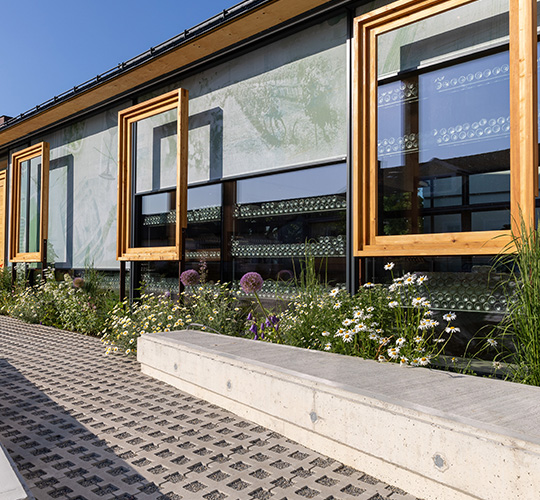 An Fensterfront halb heruntergelassene Textilscreens mit großflächigem Aufdruck