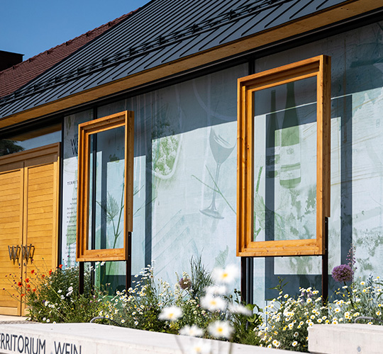 An Fensterfront heruntergelassene Textilscreens mit großflächigem Aufdruck